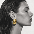 Varenna Earrings Gold worn on model – sculptural 18K gold oval stud earrings by Arina Linea